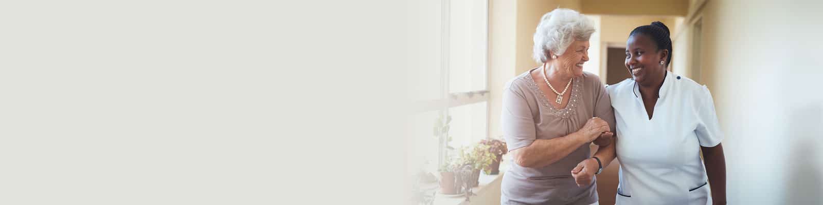 An elderly woman on a facility tour with a nurse